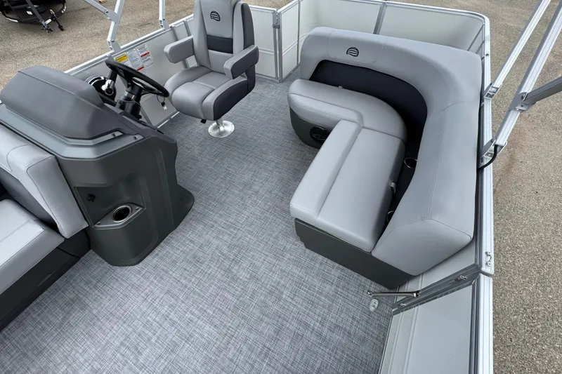 Slide: The Image of 2026 Sun Tracker Party Barge 16 DLX interior with gray seating and modern helm. - 9