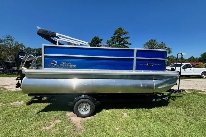 The Image of 2026 Sun Tracker Party Barge 16 DLX pontoon boat on trailer, parked on grass. - 0
