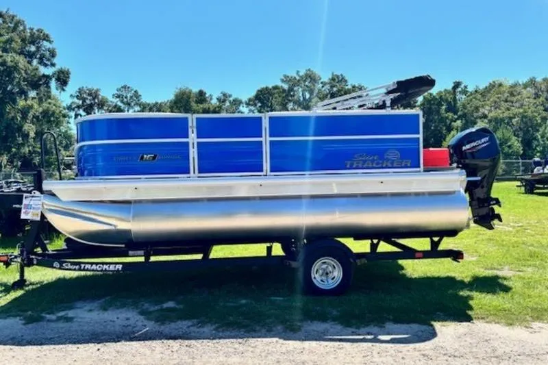 Slide: The Image of 2026 Sun Tracker Party Barge 16 DLX pontoon boat on trailer, parked outdoors. - 3