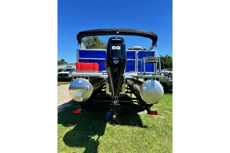 Slide: The Image of 2026 Sun Tracker Party Barge 16 DLX pontoon boat with 50 HP motor, parked on grass. - 4