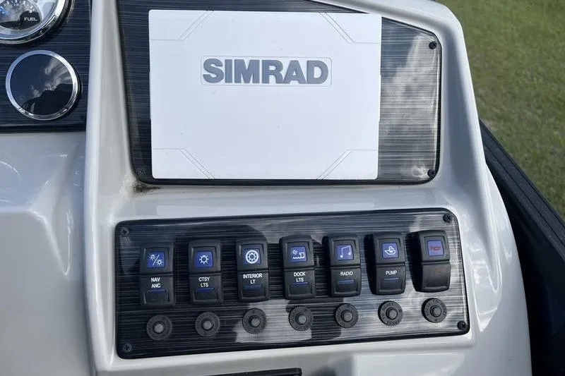 Slide: The Image of Control panel of 2025 Sylvan Mirage 822 LZ boat with Simrad display and switches. - 10