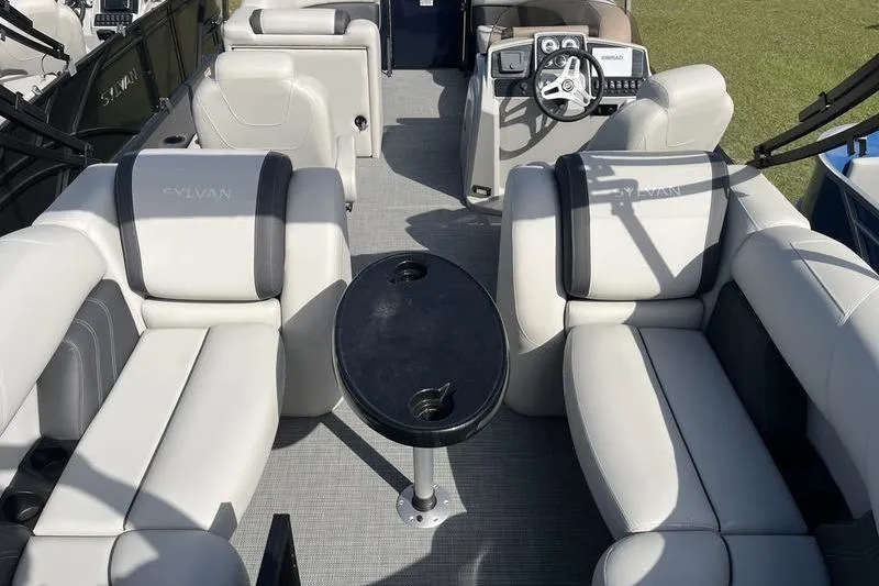 Slide: The Image of 2025 Sylvan Mirage 822 LZ pontoon boat interior with plush seating and steering console. - 6