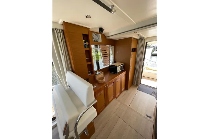 Slide: The Image of Interior of 2025 Beneteau Swift Trawler 41 Fly, featuring modern wood cabinetry and seating. - 12