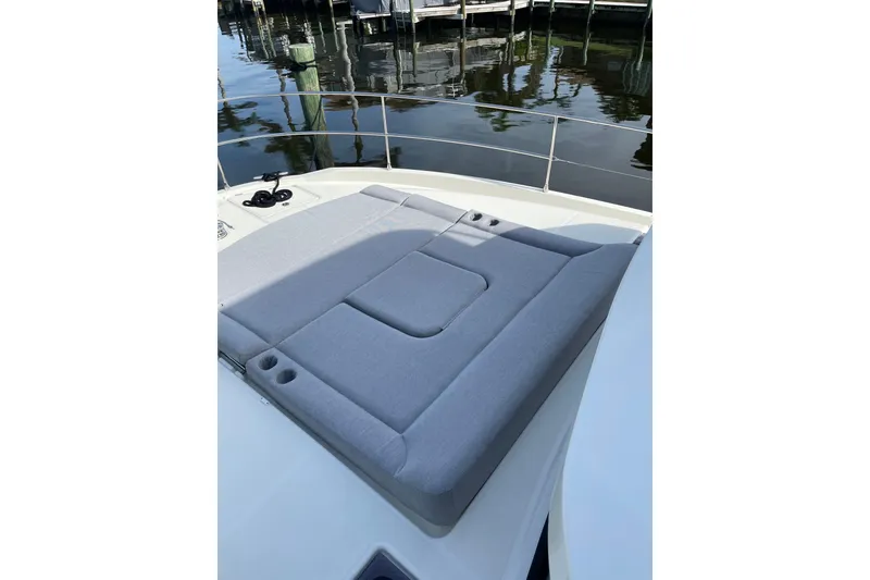 Slide: The Image of 2025 Beneteau Swift Trawler 41 Fly sunpad, docked by calm waters. - 16