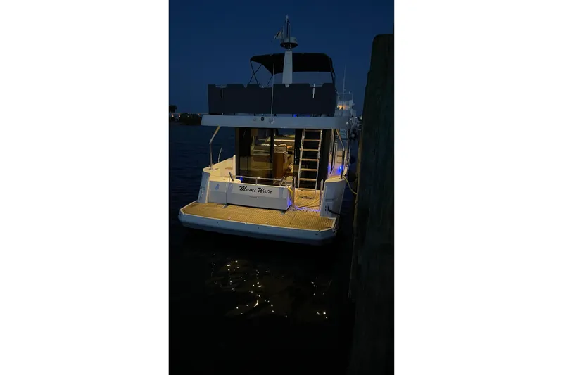 Slide: The Image of 2025 Beneteau Swift Trawler 41 Fly docked at night with illuminated deck. - 3