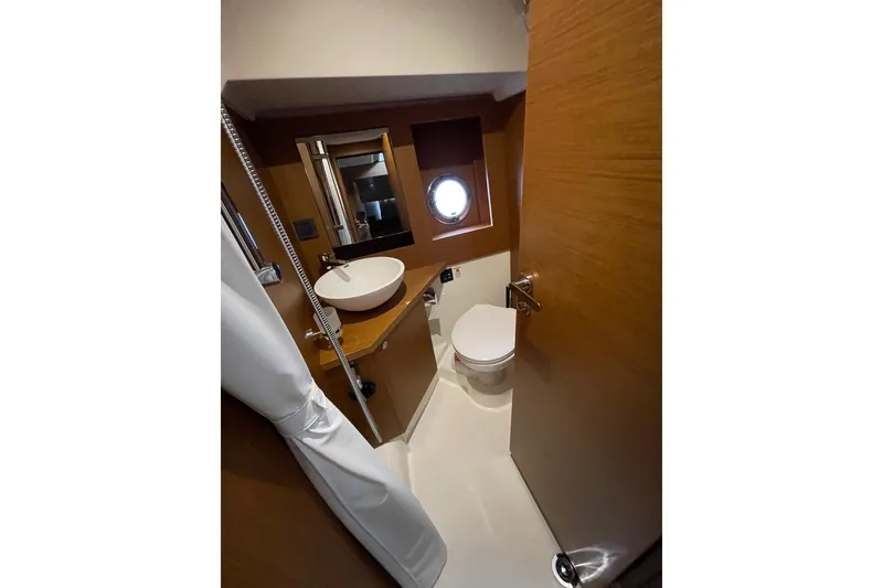Slide: The Image of Bathroom interior of 2025 Beneteau Swift Trawler 41 Fly, featuring modern fixtures and porthole. - 34