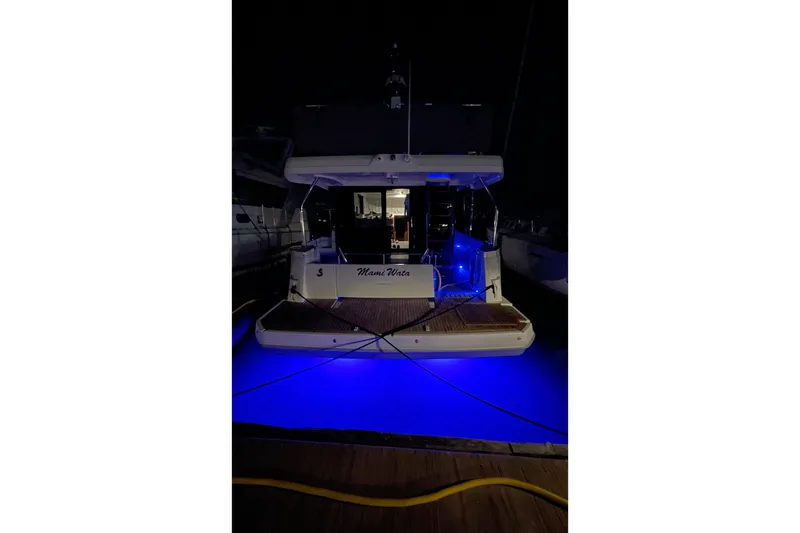 Slide: The Image of 2025 Beneteau Swift Trawler 41 Fly with blue underwater lights at night. - 5