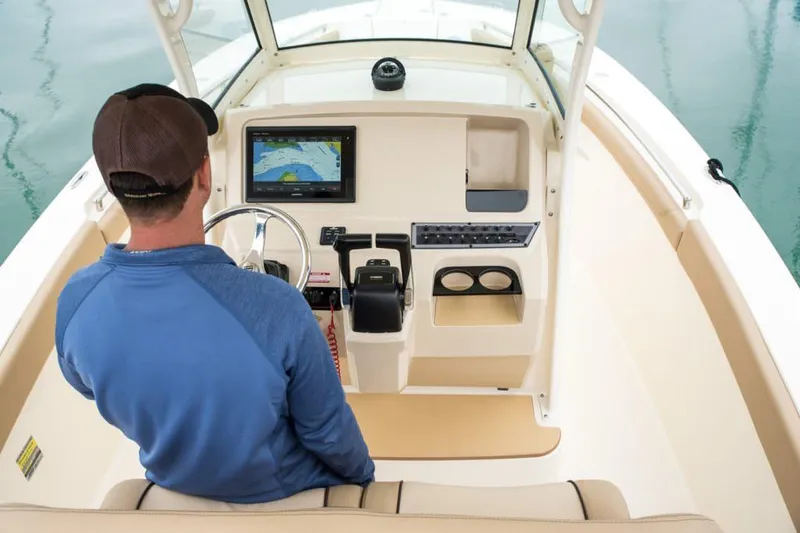 Slide: The Image of 2020 Scout 255 LXF boat with dual Yamaha 150 outboard engines, parked on pavement. - 2