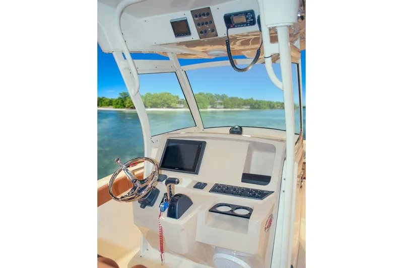 Slide: The Image of 2020 Scout 255 LXF boat with dual Yamaha 150 engines, docked on pavement. - 7