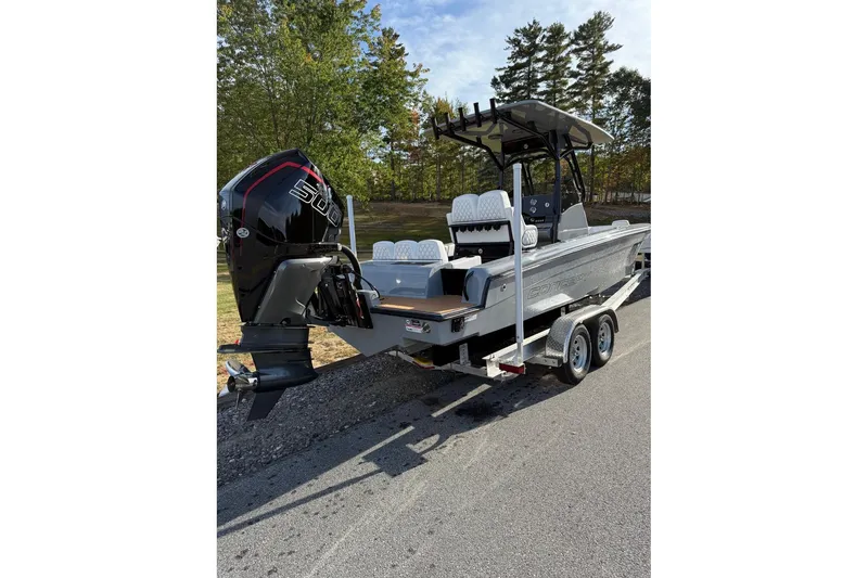 Slide: The Image of 2026 Concept 27' CC boat on trailer, featuring powerful outboard motor, parked outdoors. - 2