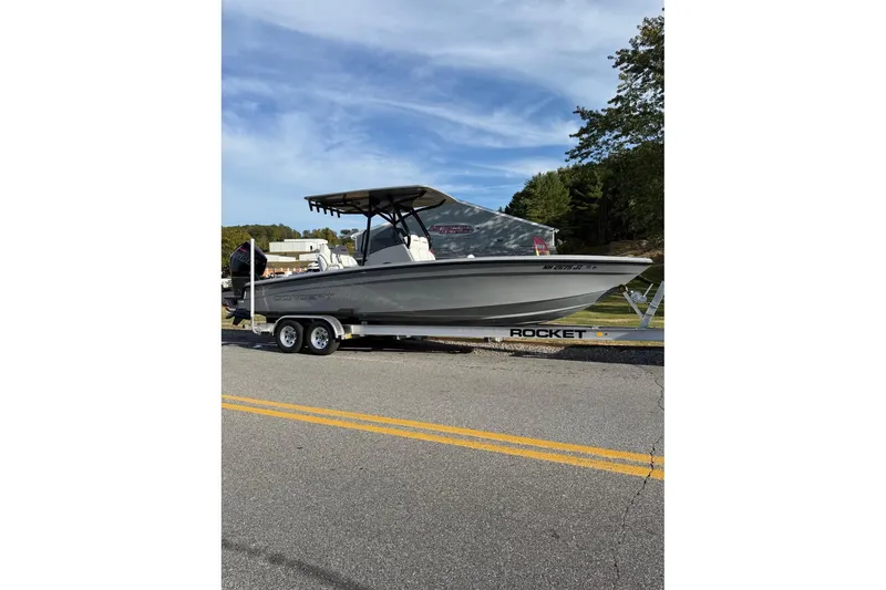 Slide: The Image of 2026 Concept 27' CC boat on trailer, parked on road with trees in background. - 20