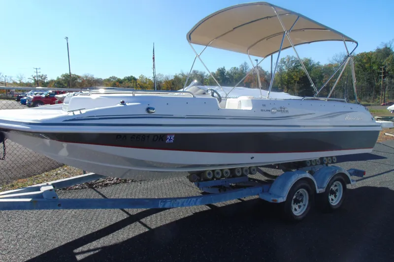 The Image of 2013 Hurricane SunDeck Sport 201 IO boat on trailer, parked outdoors. - 1