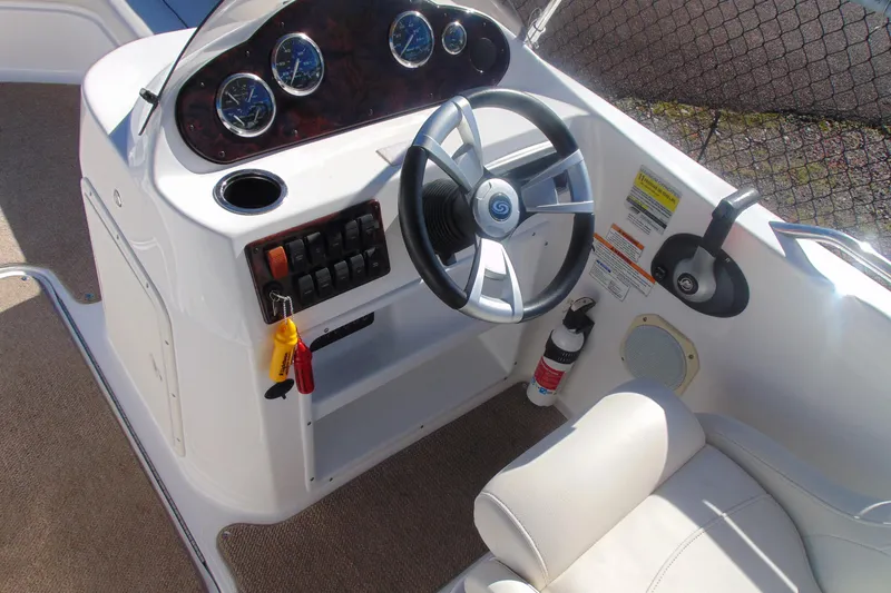 Slide: The Image of 2013 Hurricane SunDeck Sport 201 IO boat dashboard with steering wheel and gauges. - 11