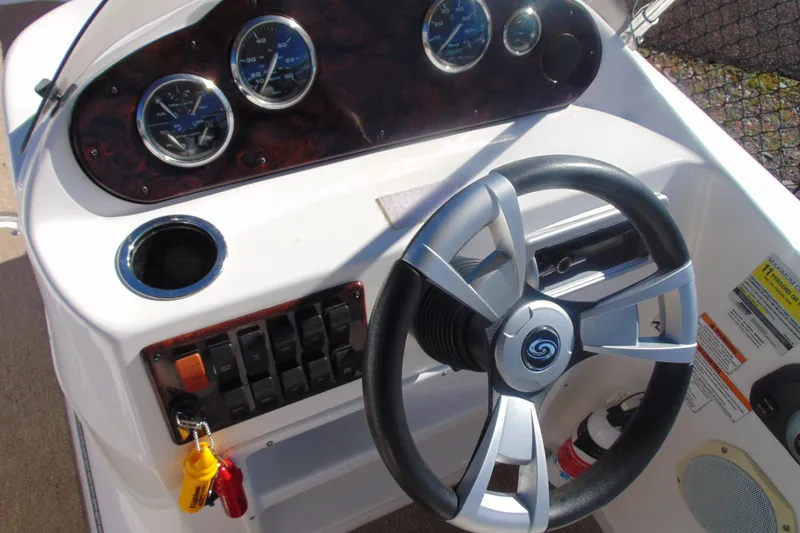 Slide: The Image of 2013 Hurricane SunDeck Sport 201 IO boat dashboard with steering wheel and gauges. - 12
