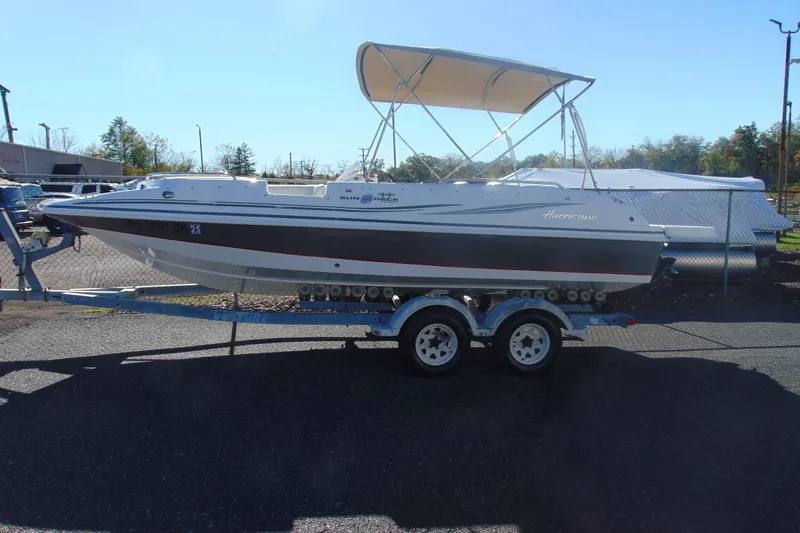 Slide: The Image of 2013 Hurricane SunDeck Sport 201 IO boat on trailer with canopy, parked outdoors. - 4