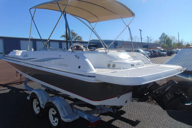 Slide: The Image of 2013 Hurricane SunDeck Sport 201 IO boat with canopy on trailer, parked outdoors. - 5