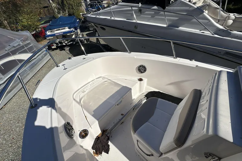 Slide: The Image of 2019 Robalo R180 Center Console boat interior with seating and storage, docked among other boats. - 10