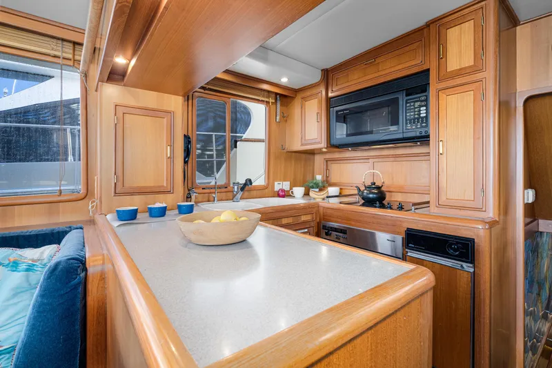 Slide: The Image of Luxurious kitchen interior of 2001 Fleming 55 Pilothouse yacht with wooden cabinetry and modern appliances. - 13