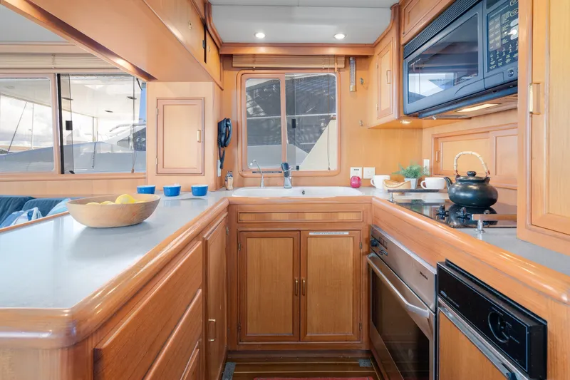 Slide: The Image of Luxurious kitchen interior of 2001 Fleming 55 Pilothouse yacht with wooden cabinetry. - 14