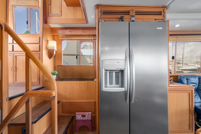 Slide: The Image of Interior of 2001 Fleming 55 Pilothouse with stainless steel refrigerator and wooden cabinetry. - 17