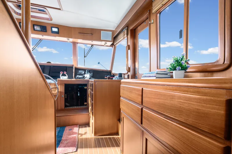 Slide: The Image of Pilothouse interior of 2001 Fleming 55, featuring wooden cabinetry and large windows. - 19