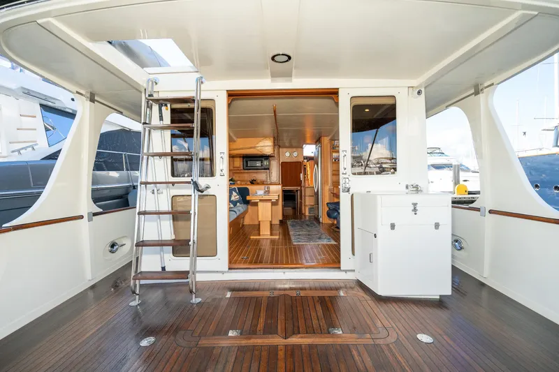 Slide: The Image of 2001 Fleming 55 Pilothouse yacht interior with wooden flooring and modern amenities. - 2