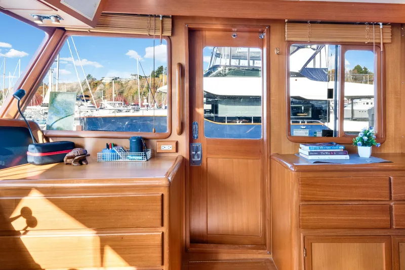Slide: The Image of Interior of 2001 Fleming 55 Pilothouse yacht with wooden cabinetry and marina view. - 23