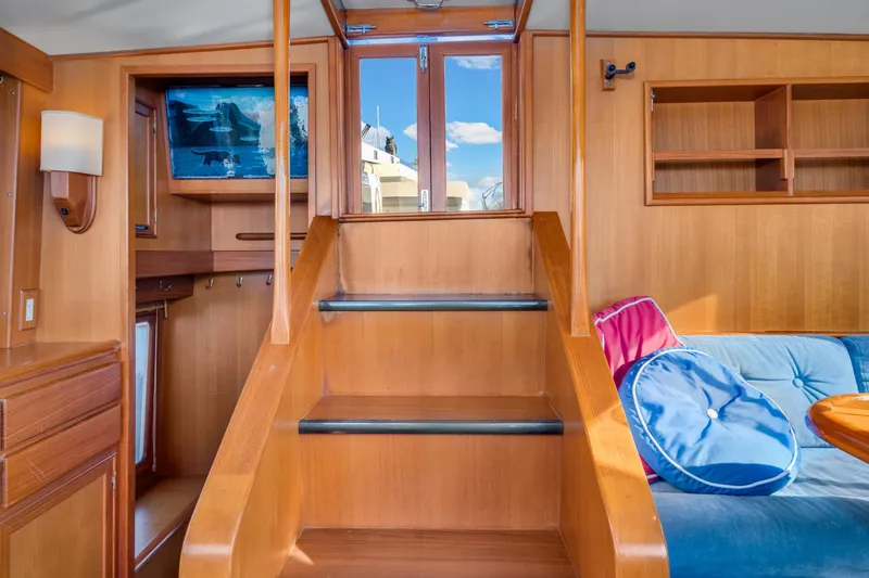 Slide: The Image of Interior of 2001 Fleming 55 Pilothouse with wooden stairs and cozy seating area. - 25