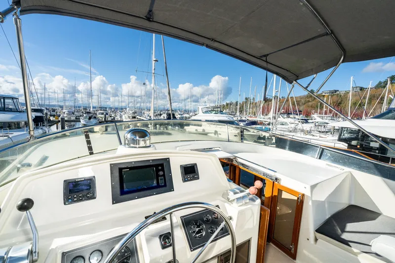 Slide: The Image of Pilothouse view of 2001 Fleming 55 yacht docked in a marina under clear blue skies. - 28