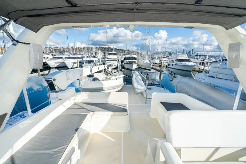 Slide: The Image of 2001 Fleming 55 Pilothouse yacht interior with marina view, featuring seating and clear skies. - 31