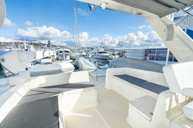 Slide: The Image of 2001 Fleming 55 Pilothouse yacht deck with seating, docked in a sunny marina. - 32