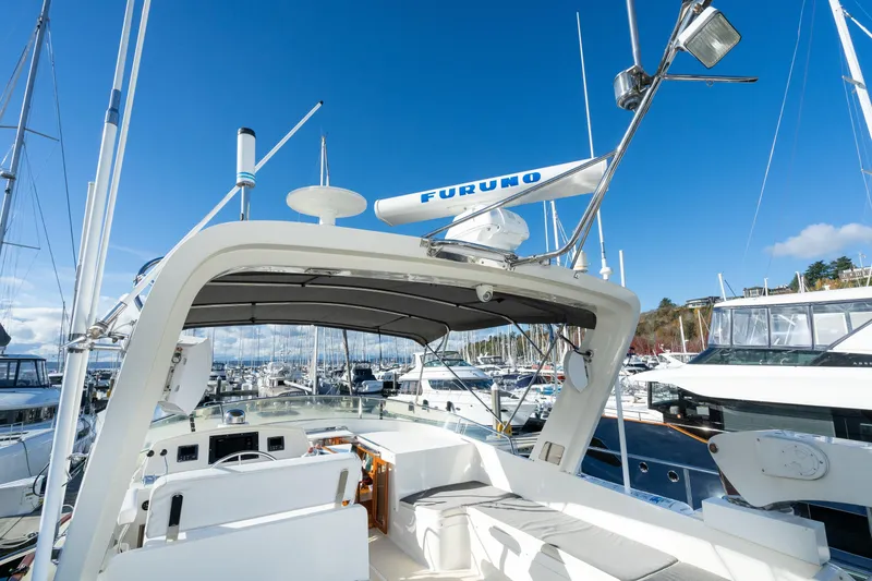 Slide: The Image of 2001 Fleming 55 Pilothouse yacht at marina, featuring open deck and navigation equipment. - 35