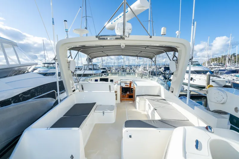 Slide: The Image of 2001 Fleming 55 Pilothouse yacht interior with seating, docked in a marina under blue skies. - 38