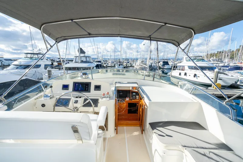 Slide: The Image of Pilothouse of 2001 Fleming 55 yacht, featuring helm station and marina view. - 39