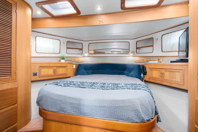 Slide: The Image of Luxurious bedroom interior of 2001 Fleming 55 Pilothouse yacht with wood accents and skylights. - 48