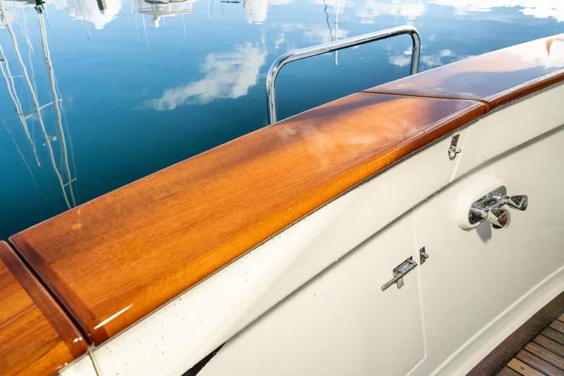 Slide: The Image of Polished wood railing on 2001 Fleming 55 Pilothouse yacht, reflecting in calm water. - 54