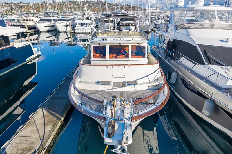 Slide: The Image of 2001 Fleming 55 Pilothouse yacht docked in a marina, surrounded by other boats. - 67