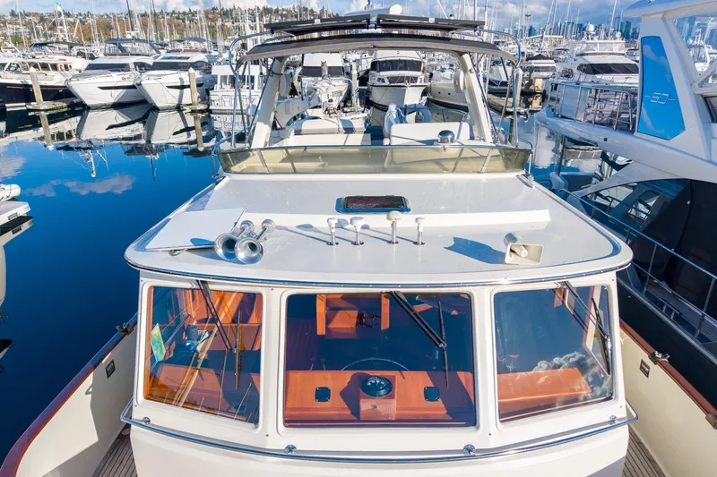 Slide: The Image of Fleming 55 Pilothouse 2001 yacht docked in a marina, surrounded by other boats. - 68