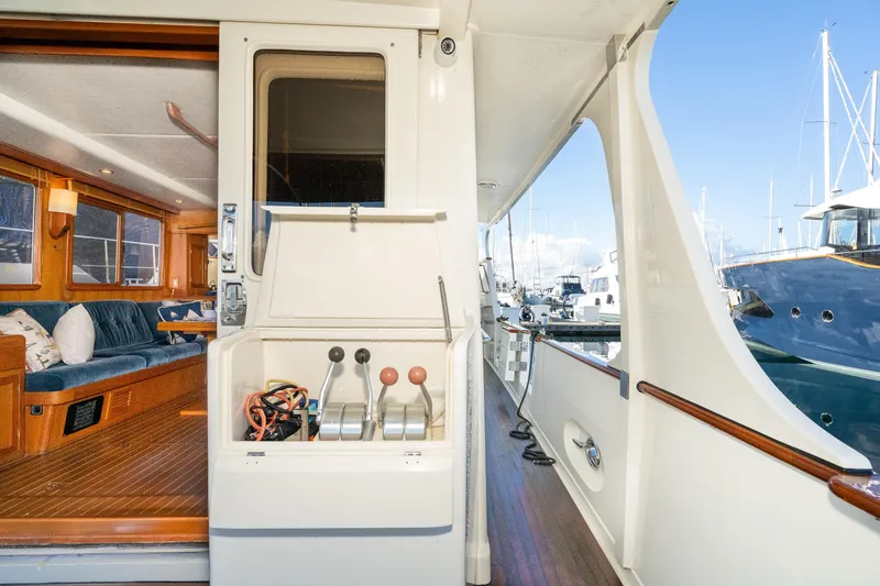 Slide: The Image of 2001 Fleming 55 Pilothouse yacht interior and deck, showcasing luxurious seating and marina view. - 7