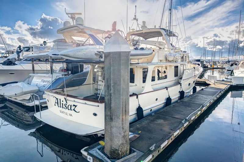 Slide: The Image of 2001 Fleming 55 Pilothouse yacht docked at marina under a vibrant sky. - 70