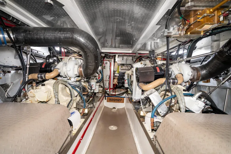 Slide: The Image of Engine room of a 2001 Fleming 55 Pilothouse yacht, showcasing dual engines and mechanical systems. - 76