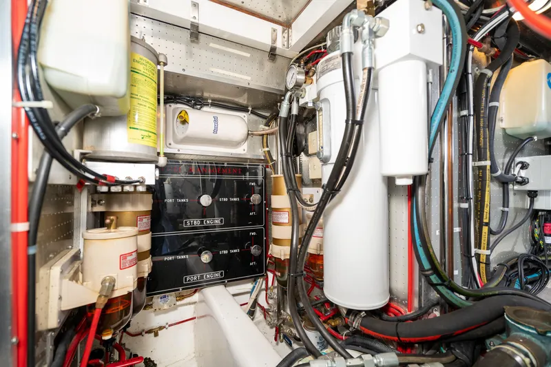 Slide: The Image of Engine room of a 2001 Fleming 55 Pilothouse yacht, showcasing complex machinery and wiring. - 79