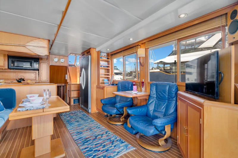 Slide: The Image of Luxurious interior of 2001 Fleming 55 Pilothouse yacht with blue chairs and wooden accents. - 8