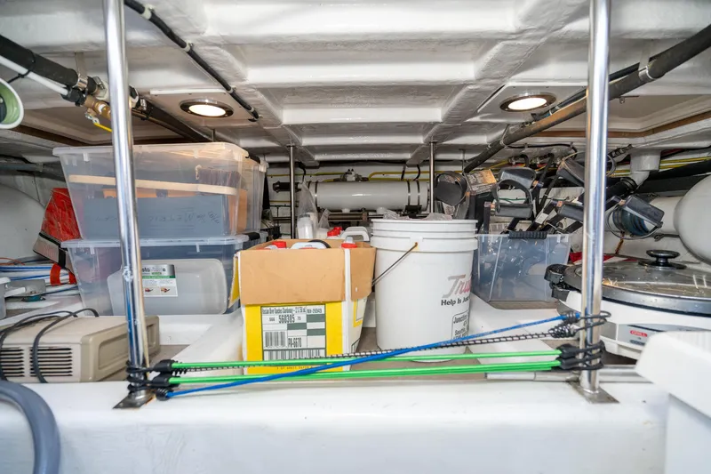 Slide: The Image of Storage area in a 2001 Fleming 55 Pilothouse, filled with various containers and equipment. - 82