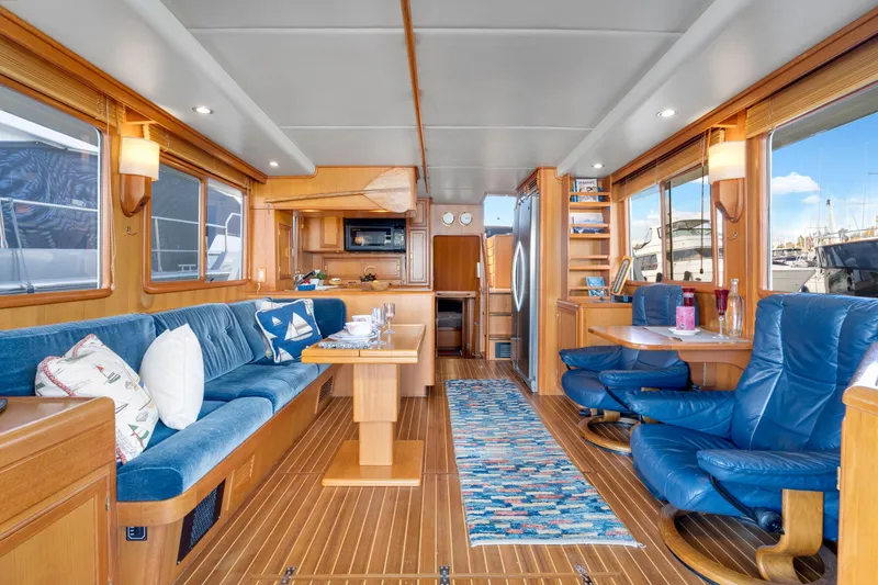 Slide: The Image of Luxurious interior of 2001 Fleming 55 Pilothouse yacht with blue seating and wooden accents. - 9