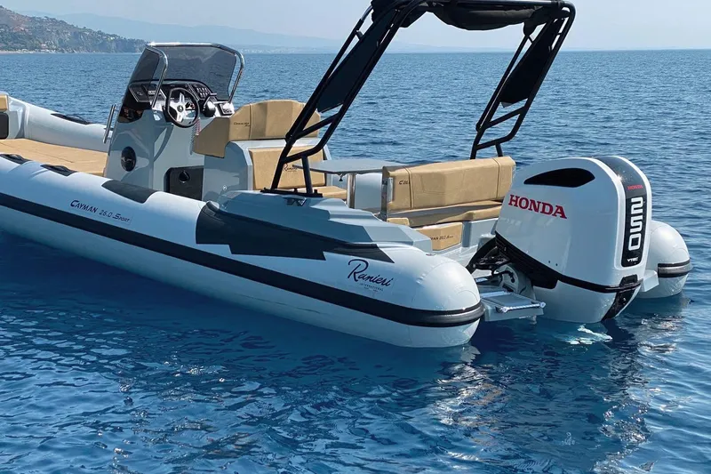 Slide: The Image of 2023 Ranieri CAYMAN 26 SPORT boat with Honda engine on calm blue water. - 16