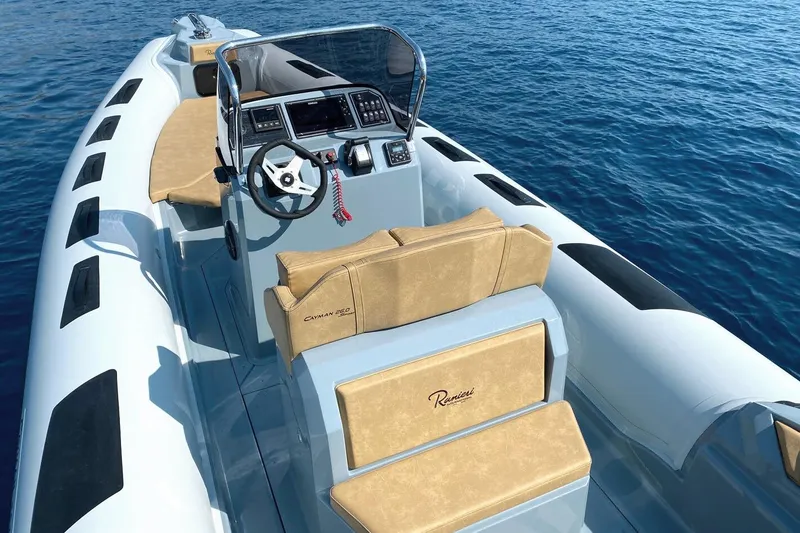 Slide: The Image of 2023 Ranieri CAYMAN 26 SPORT boat interior with steering wheel and seating on blue water. - 7