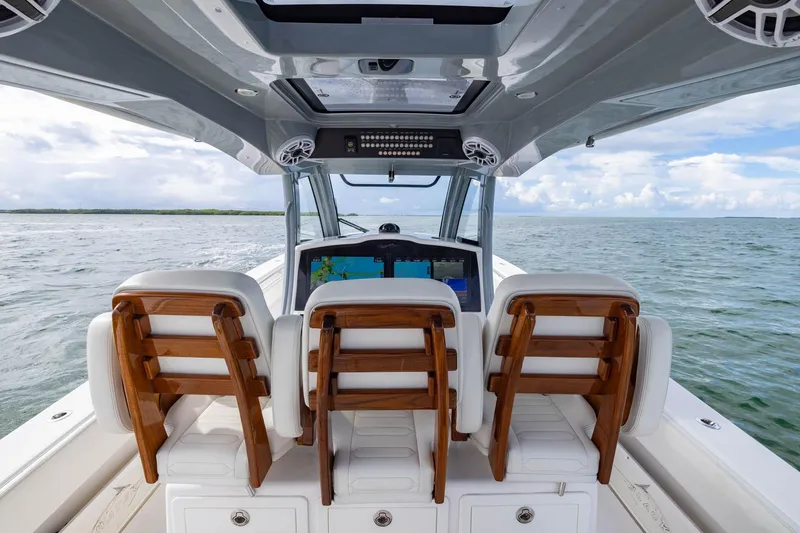 Slide: The Image of 2024 Blackwater 43 Sportfish boat interior with wooden seats, navigating open waters. - 57