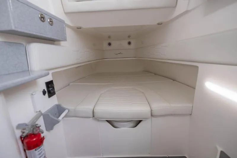 Slide: The Image of 2024 Blackwater 43 Sportfish cabin interior with white cushioned seating and storage. - 61