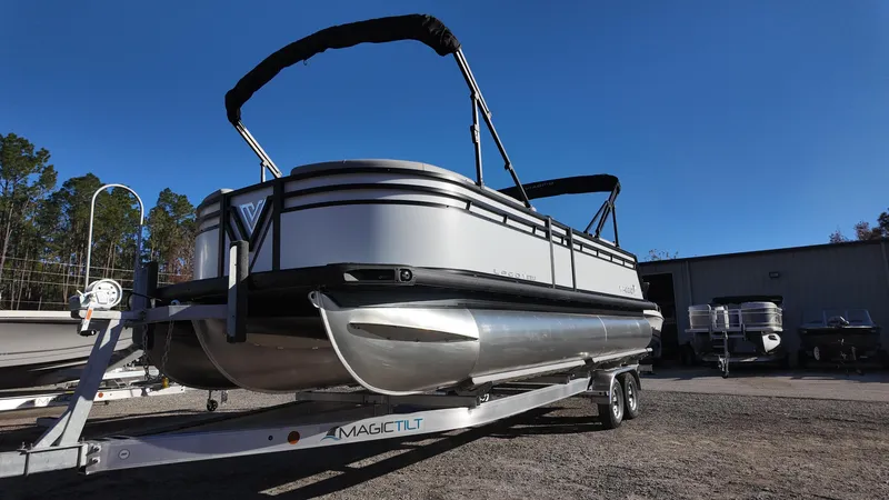 Slide: The Image of 2025 Viaggio V22U pontoon boat on trailer, parked outdoors under clear blue sky. - 6